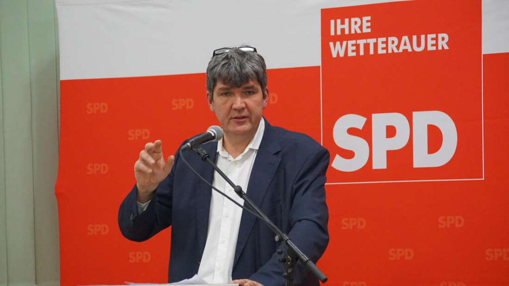 Matthias Körner am Rednerpult im Hintergrund Aufsteller SPD Wetterau